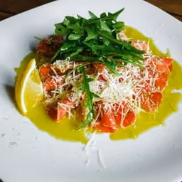 Carpaccio di pesce con rucola e limone