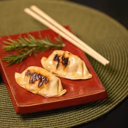 Gyoza con salsa di soia su piatto rosso